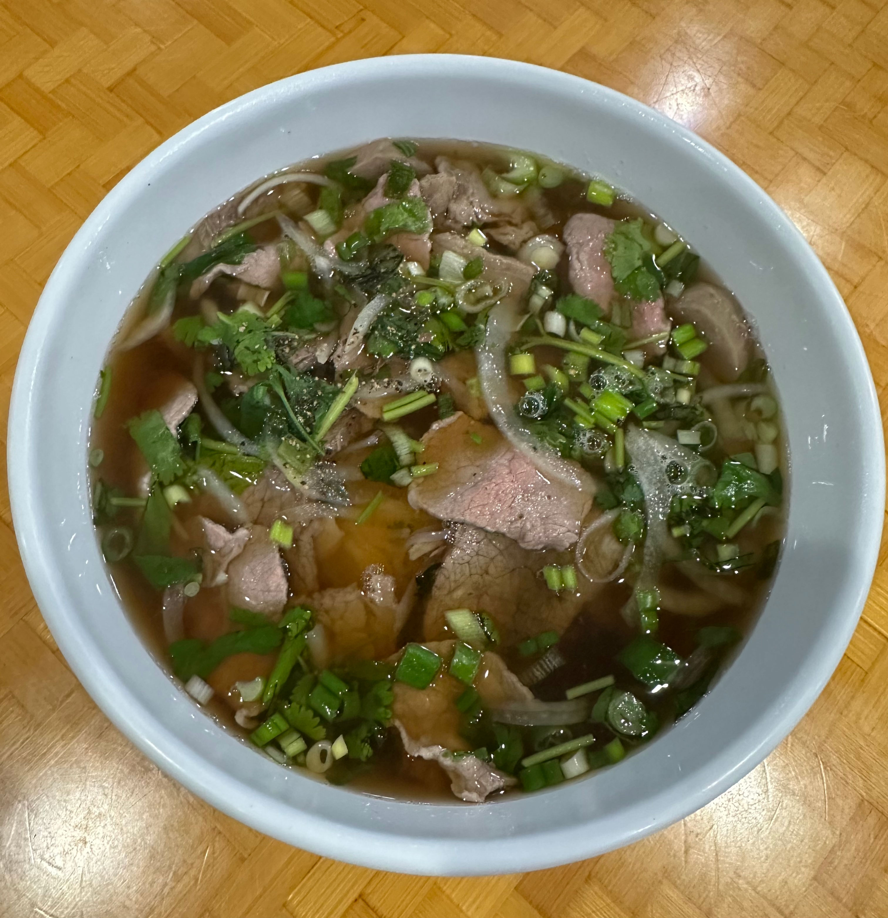 bowl of pho with beef and scallions