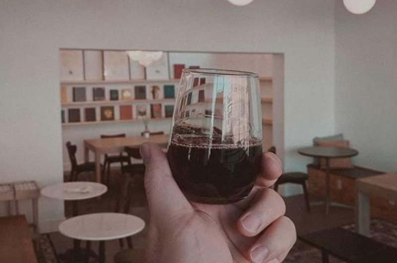 Photo of a wine glass being held up at Analog Wine Bar.