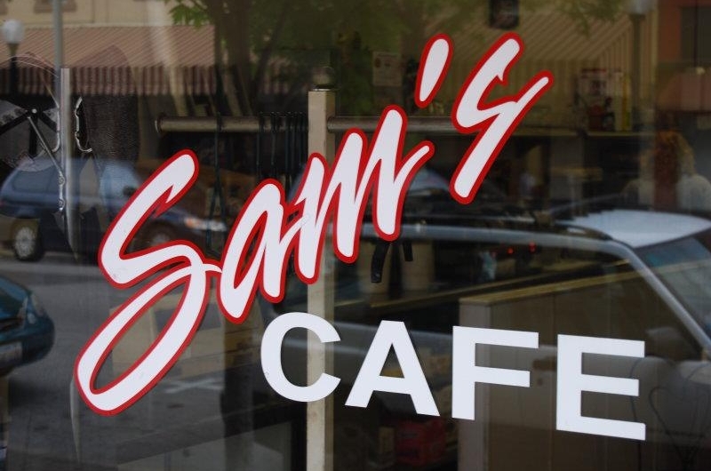 Sign on the door for Sam\'s Cafe reading \