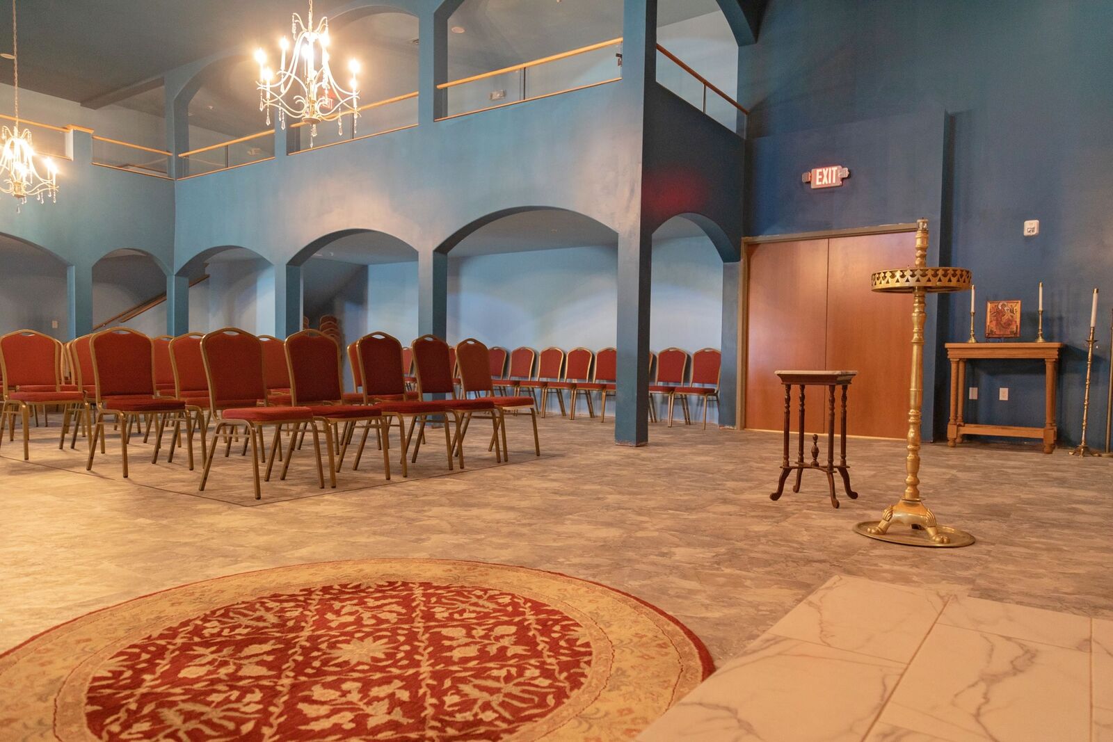rows of red chairs in a church with blue walls