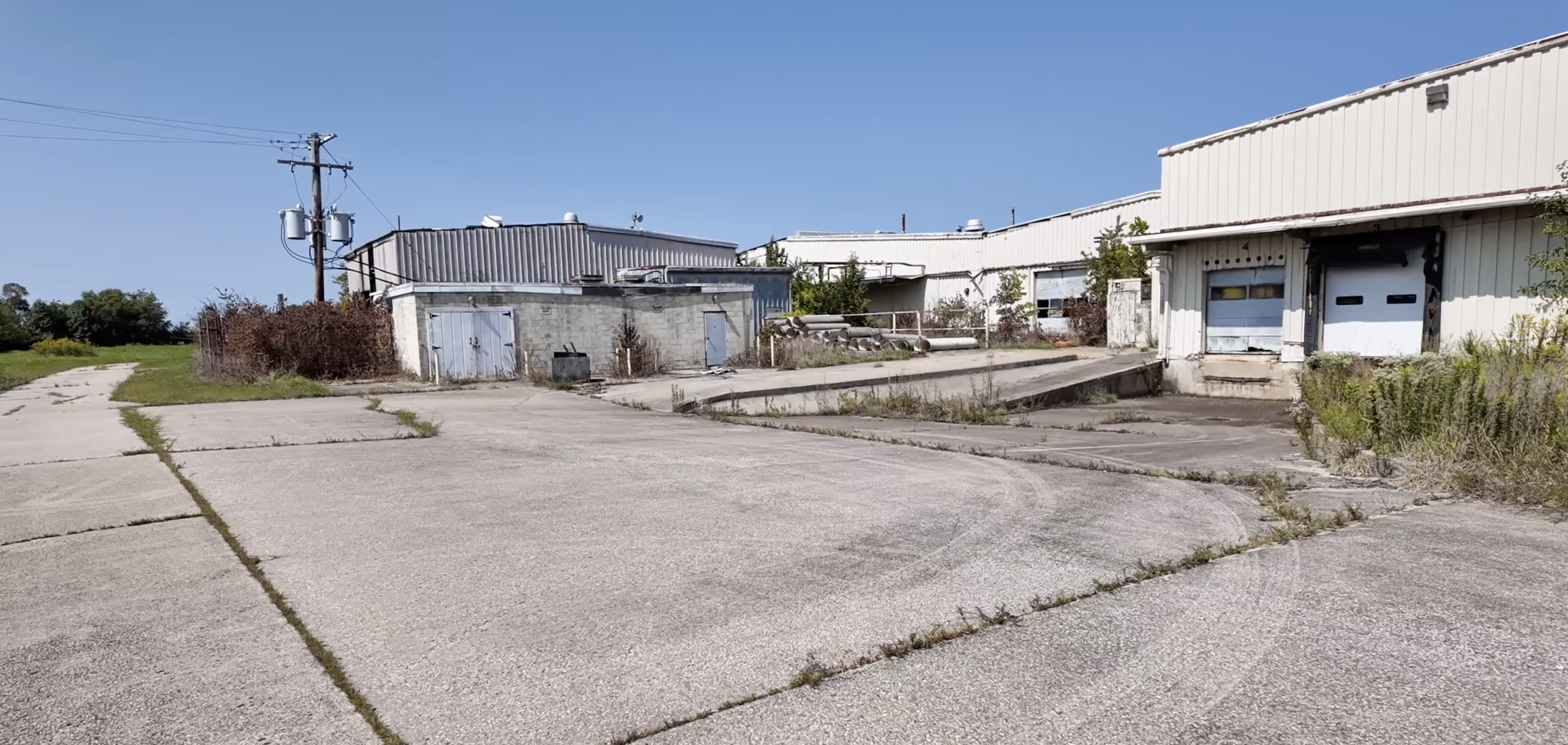 exterior of a large, off-white building with garage loading doors