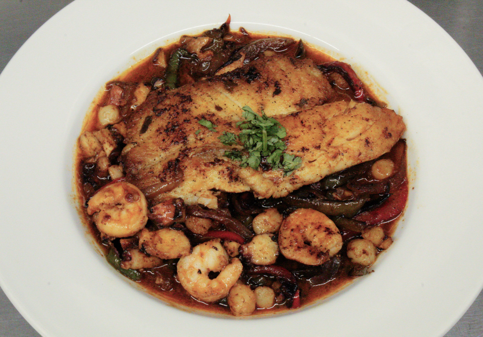 Grilled salmon topped with grilled shrimp, octopus, and veggies
