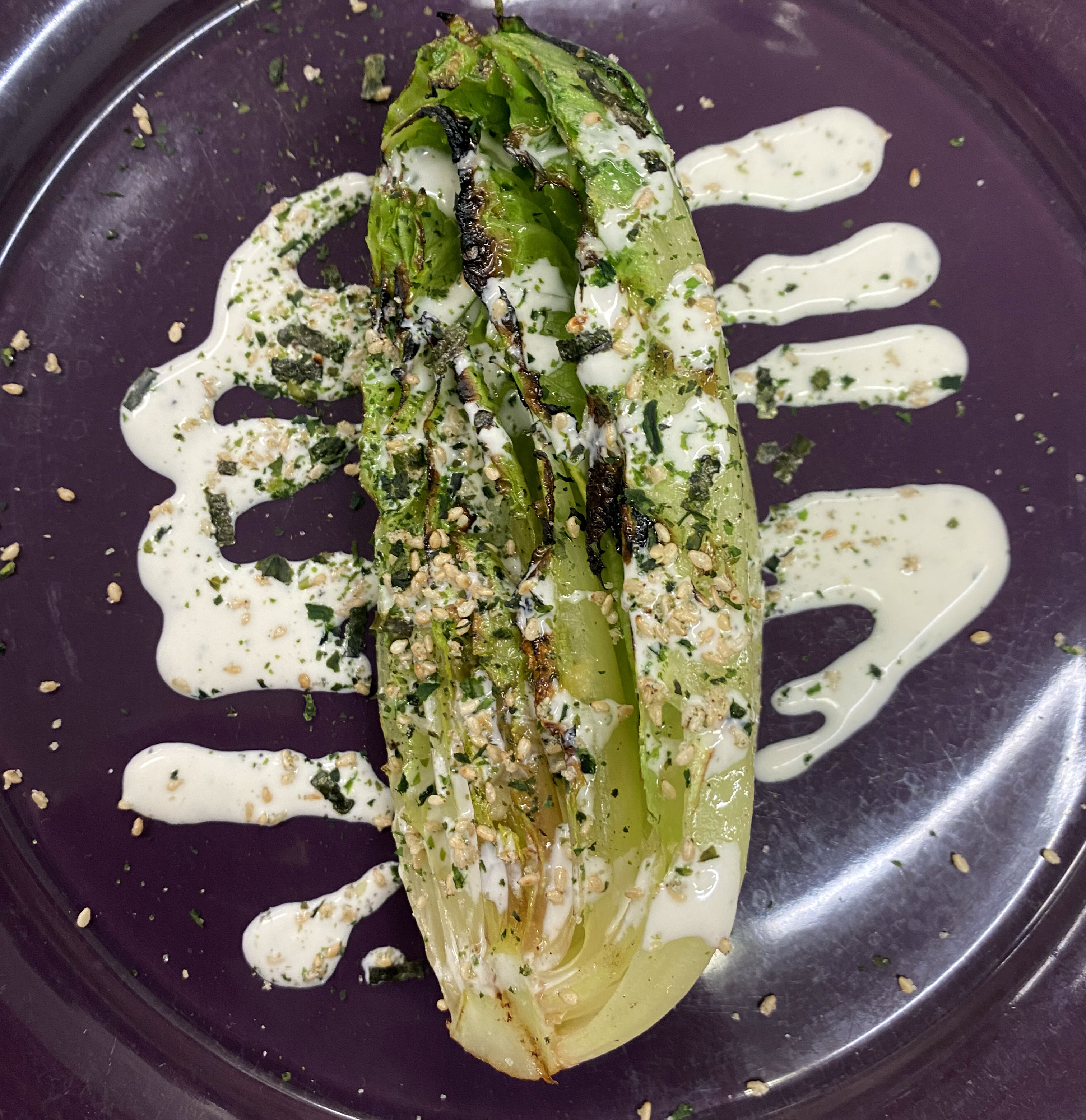 Grilled romaine lettuce drizzled with ranch and seasoning