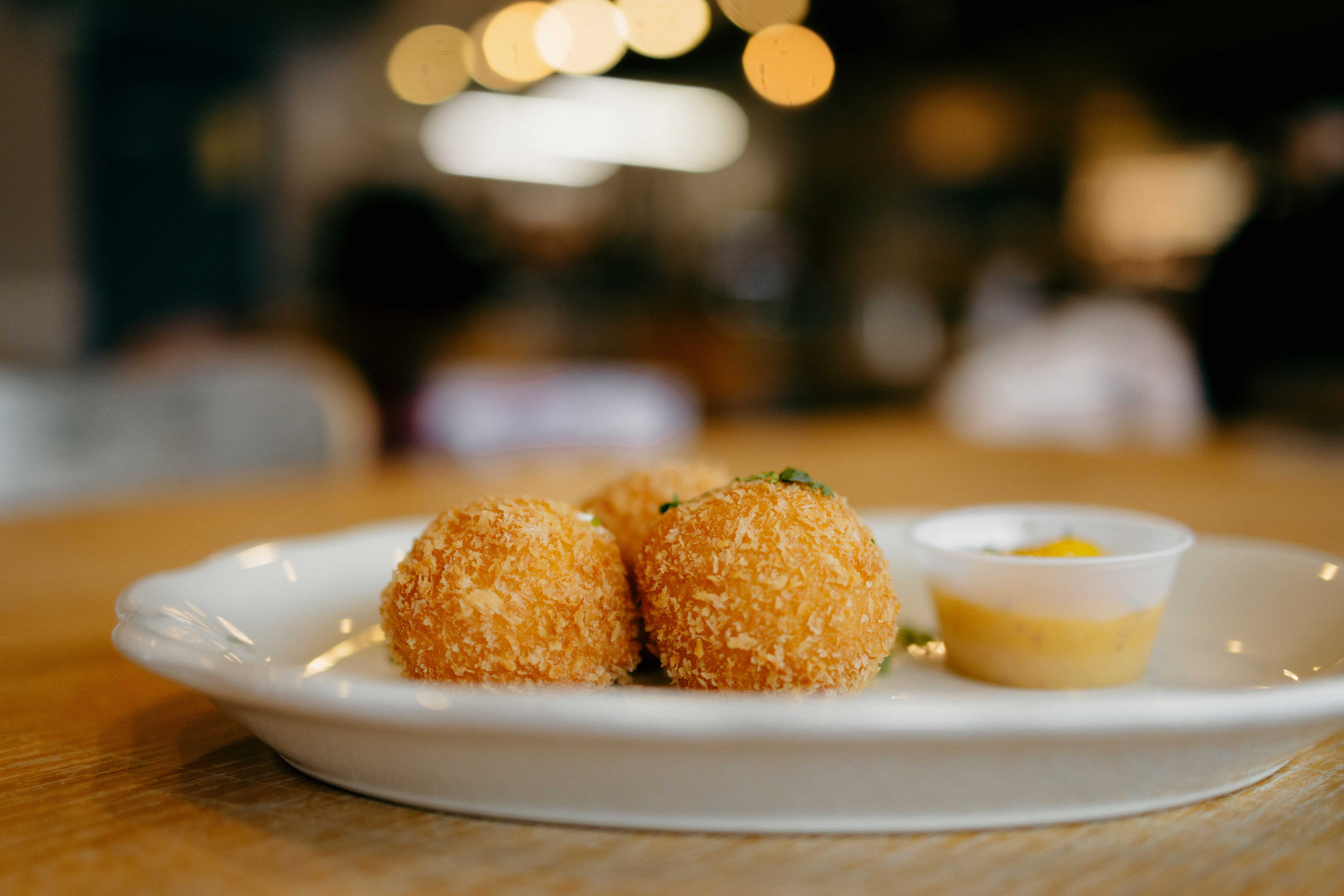 Croissant topped with powdered sugar filled with whipped cream and strawberries, cup of coffee