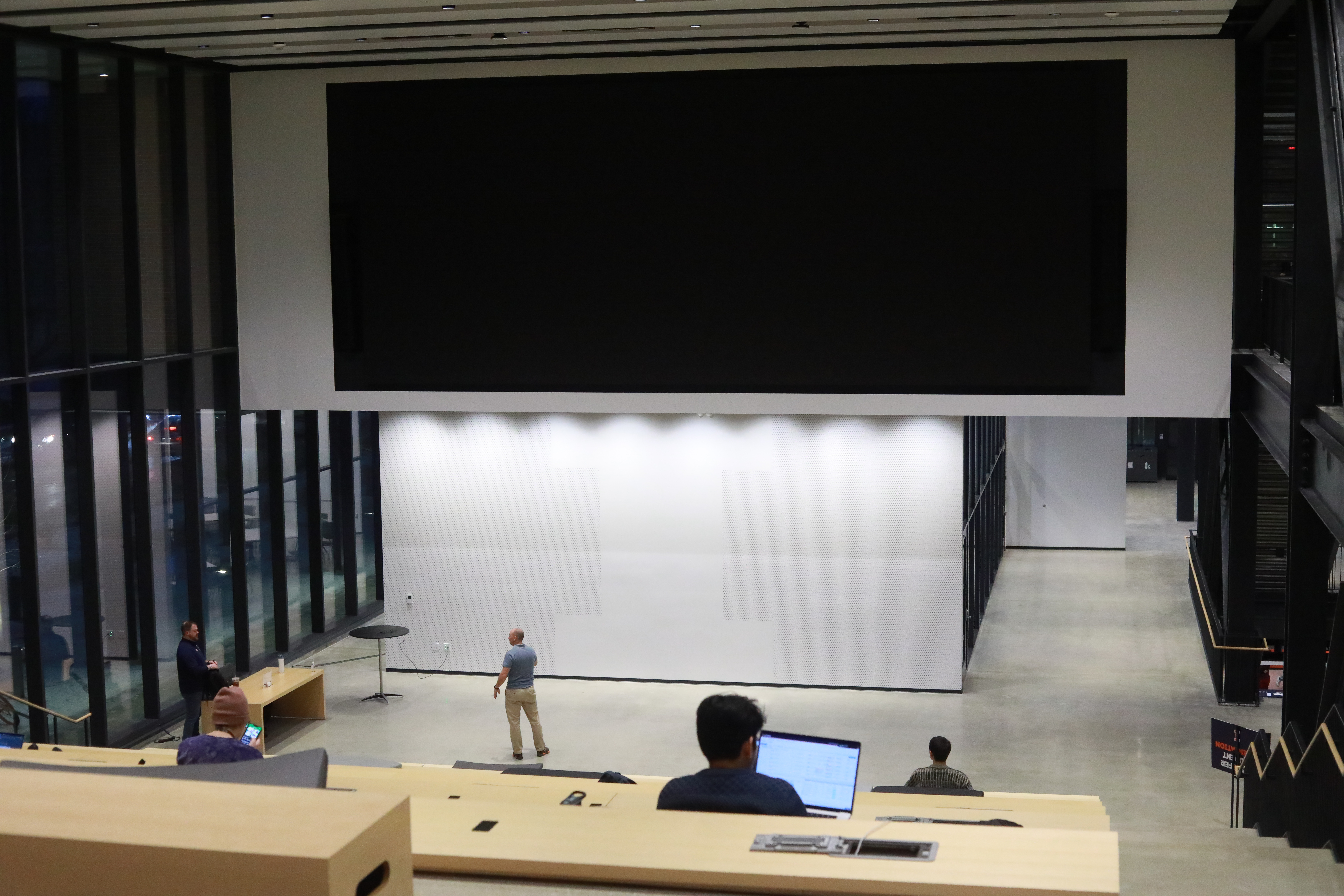 Large video board with students facing it
