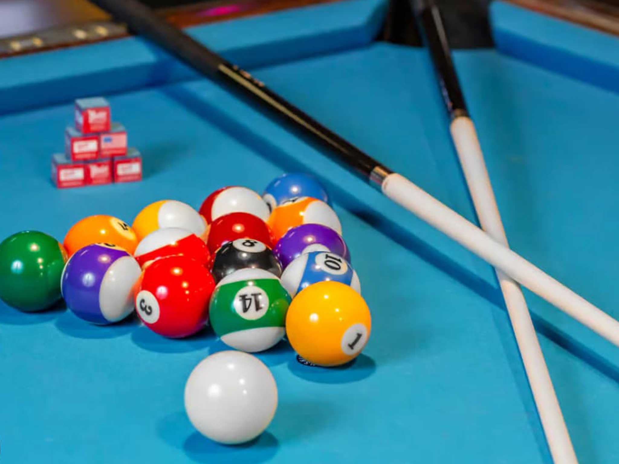 Pool cue sticks and balls on top of a pool table