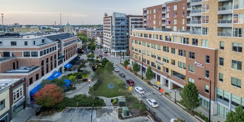 overhead view of downtown with brown brick buildings and a road in the middle