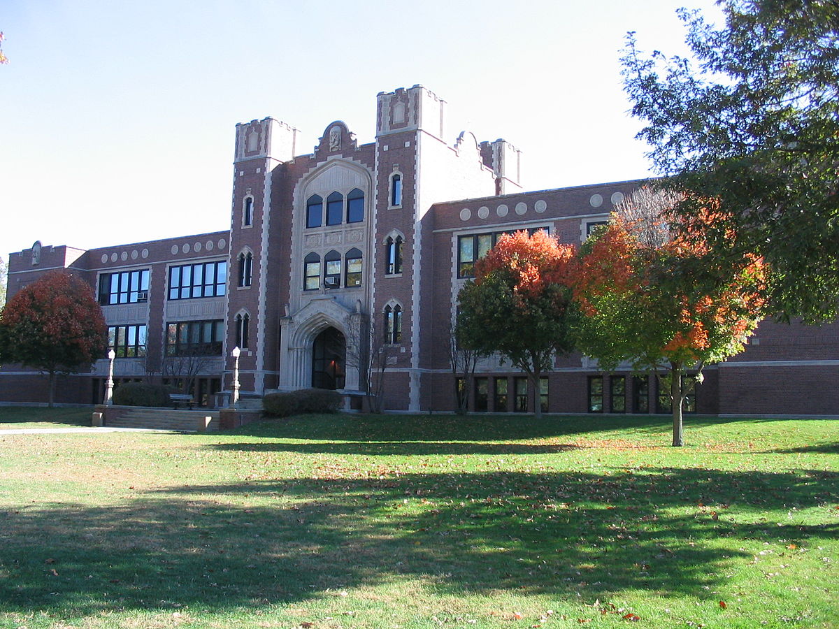 brown and tan brick building with towers over the entrance
