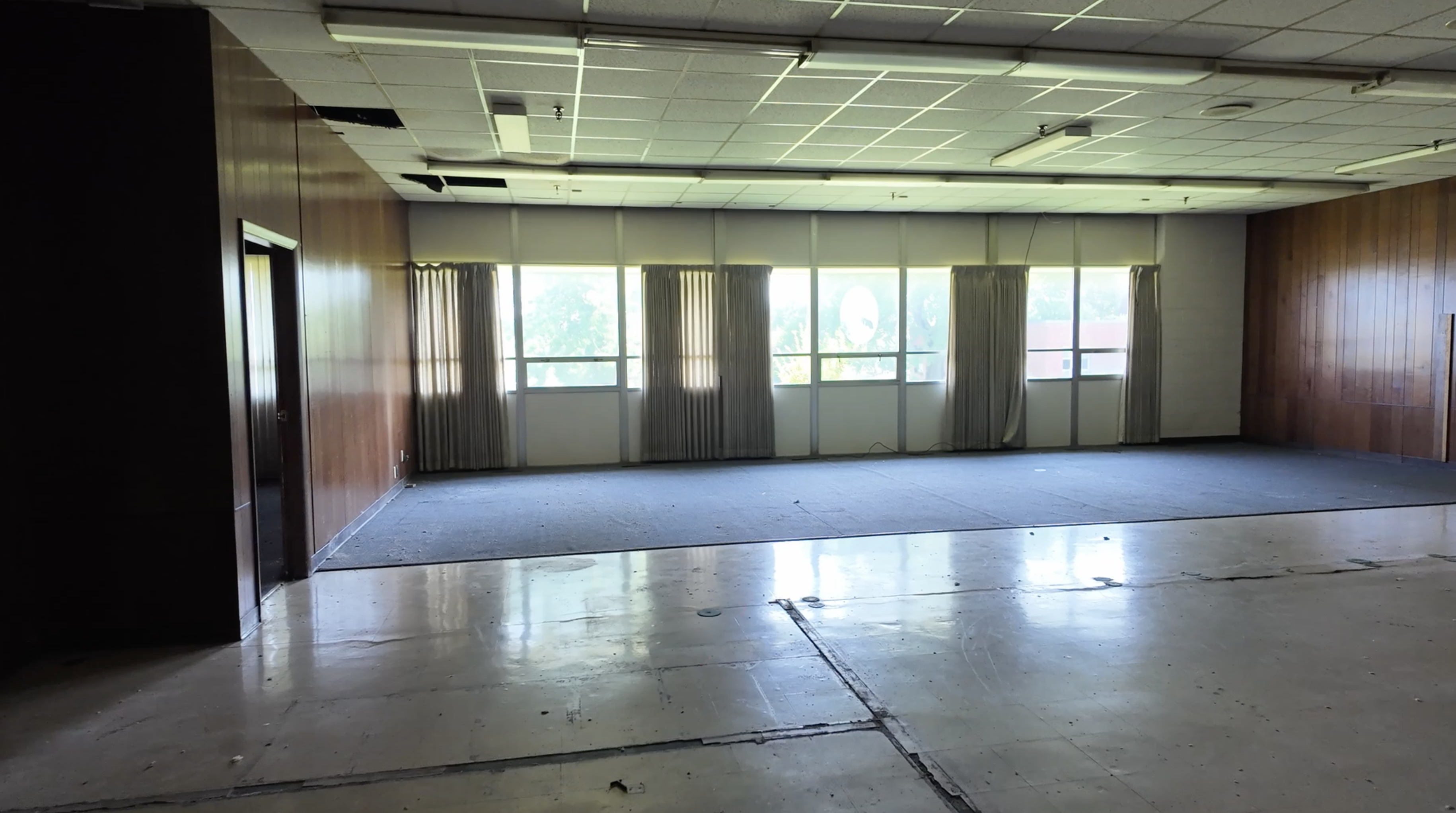 interior meeting room with cracked floor and 3 windows