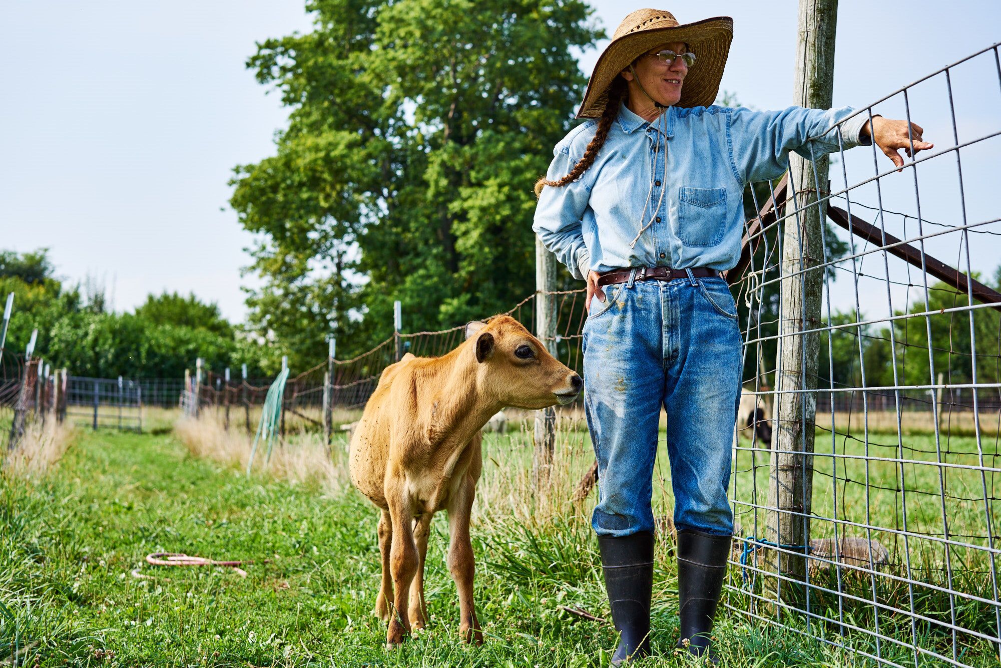 Joy of Illinois Farm owner and goat looking at the farm.