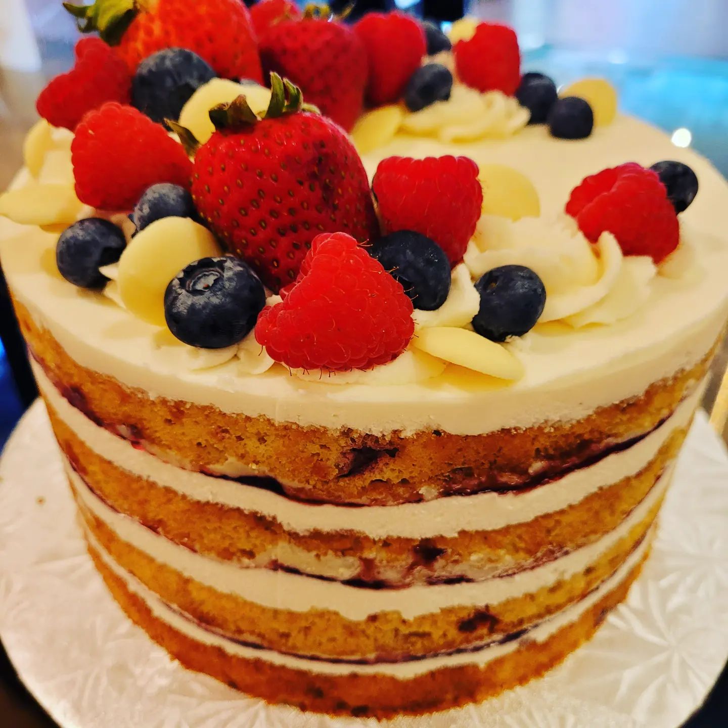 White chocolate raspberry cake topped with mixed berries.