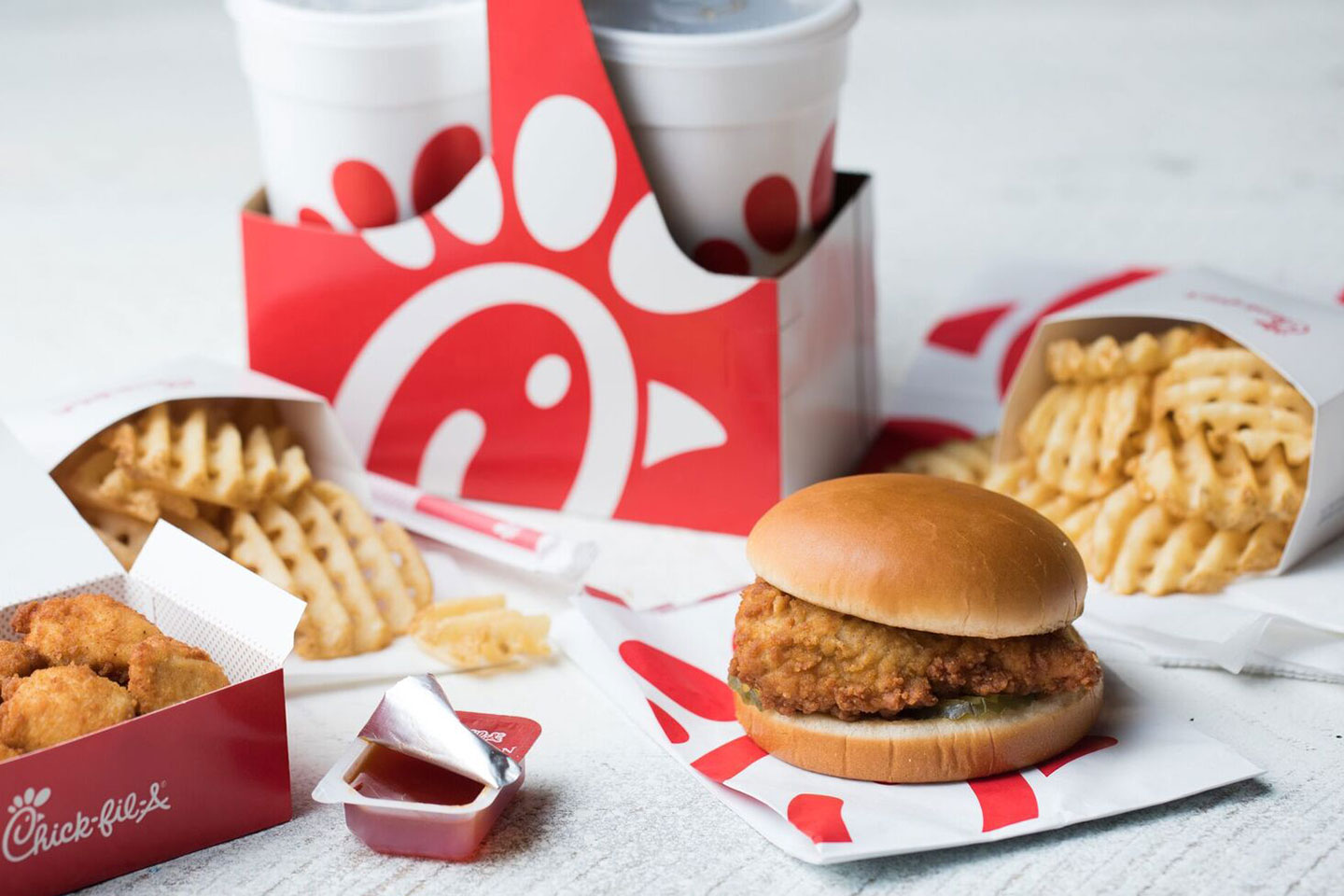 Meal from Chick-Fil-A including drinks, chicken sandwich, friends, and chicken nuggets.