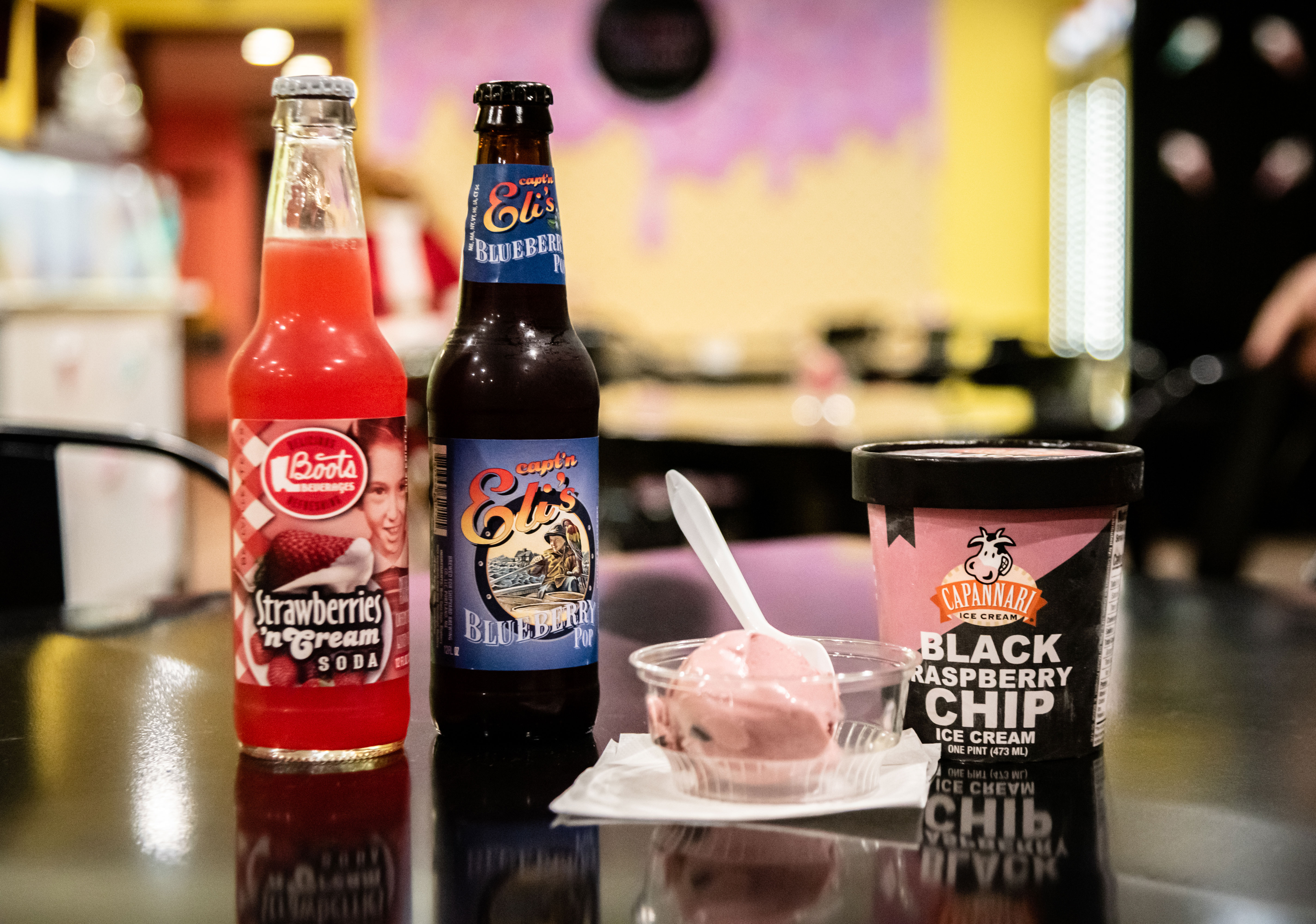 ice cream in a cup and two bottled sodas