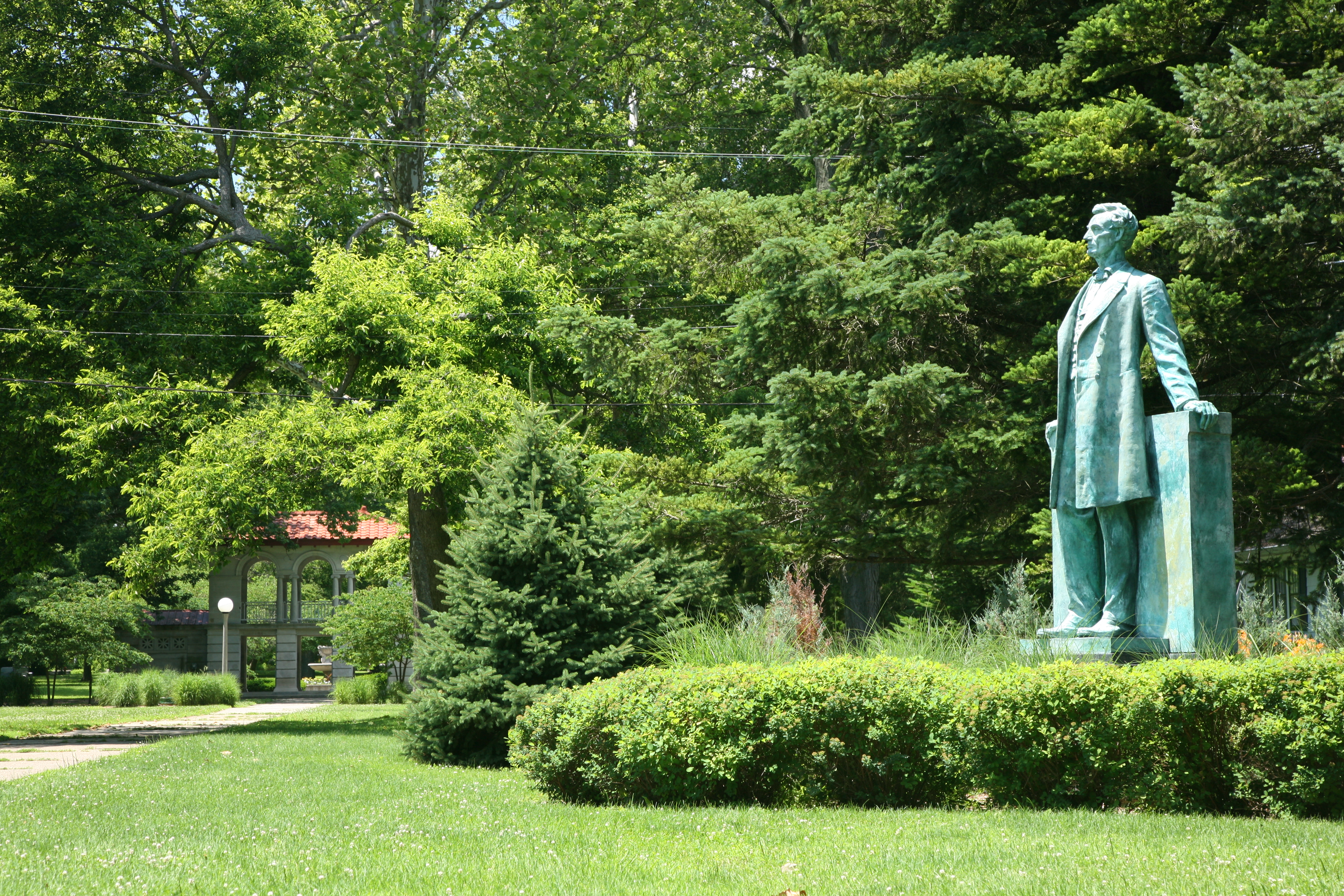 teal colored statue of Abe Lincoln surrounded by trees