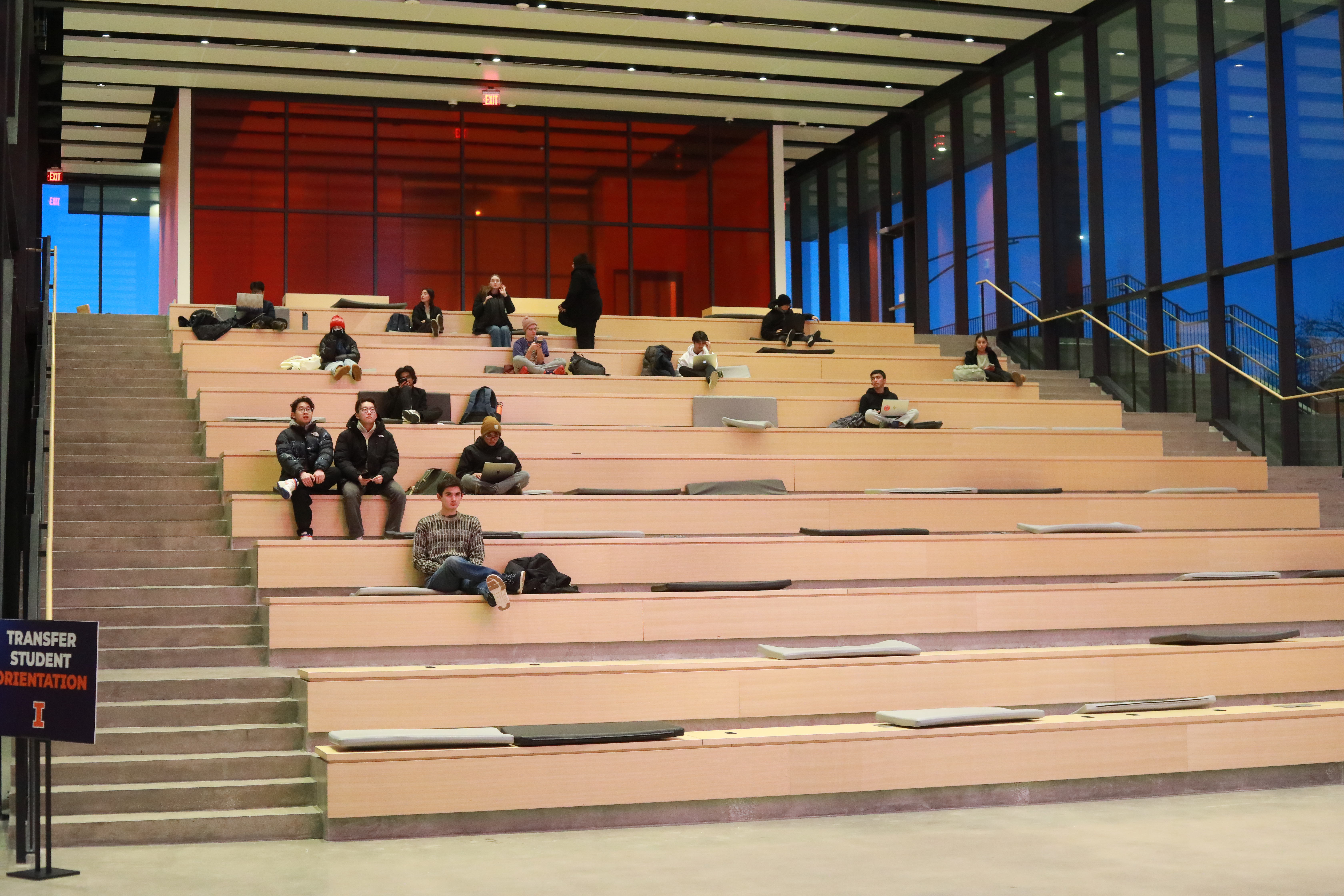 Large room with bleacher-style seating and college students studying
