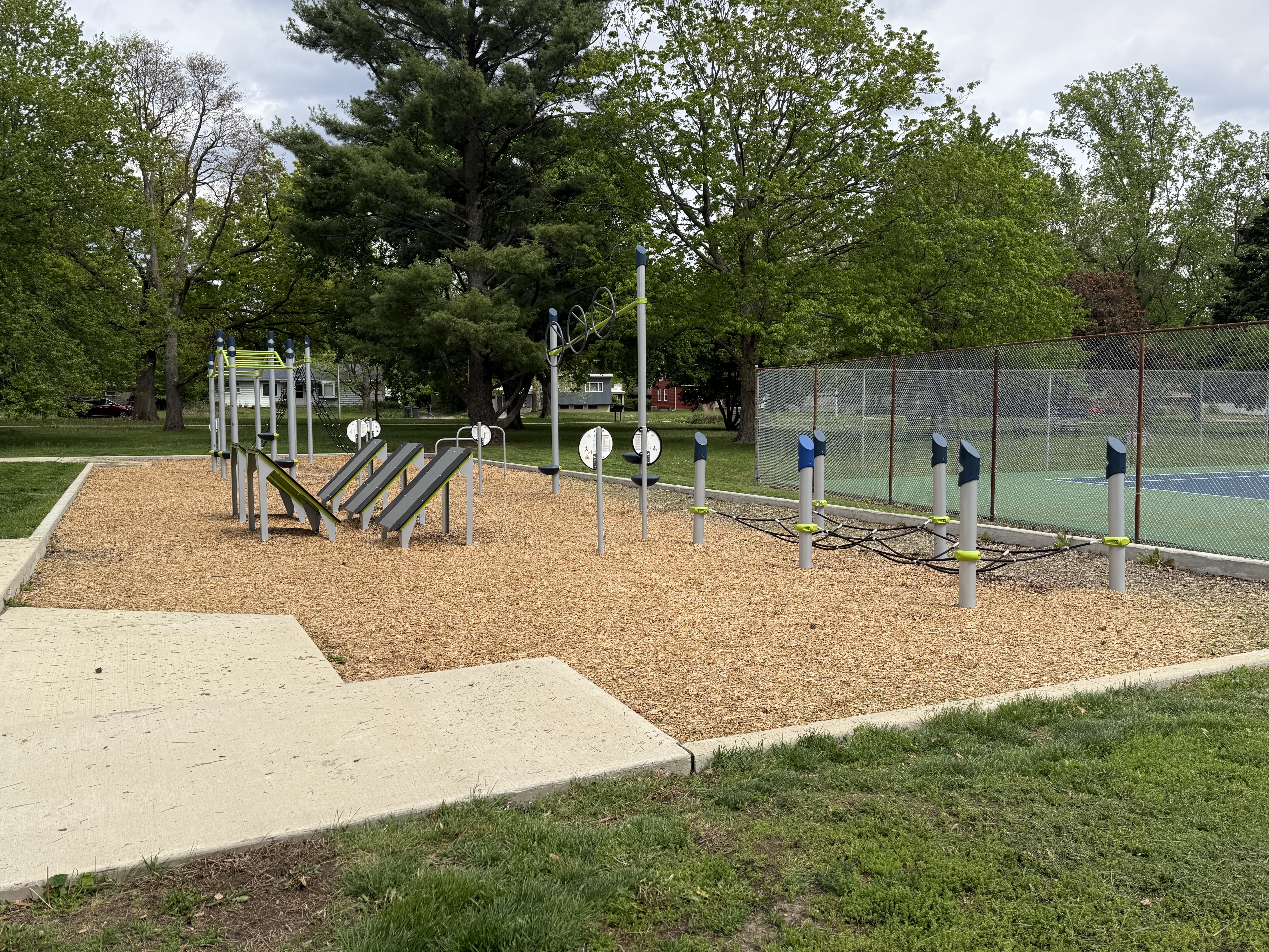small fitness outdoor fitness area over woodchips, with trees in the background
