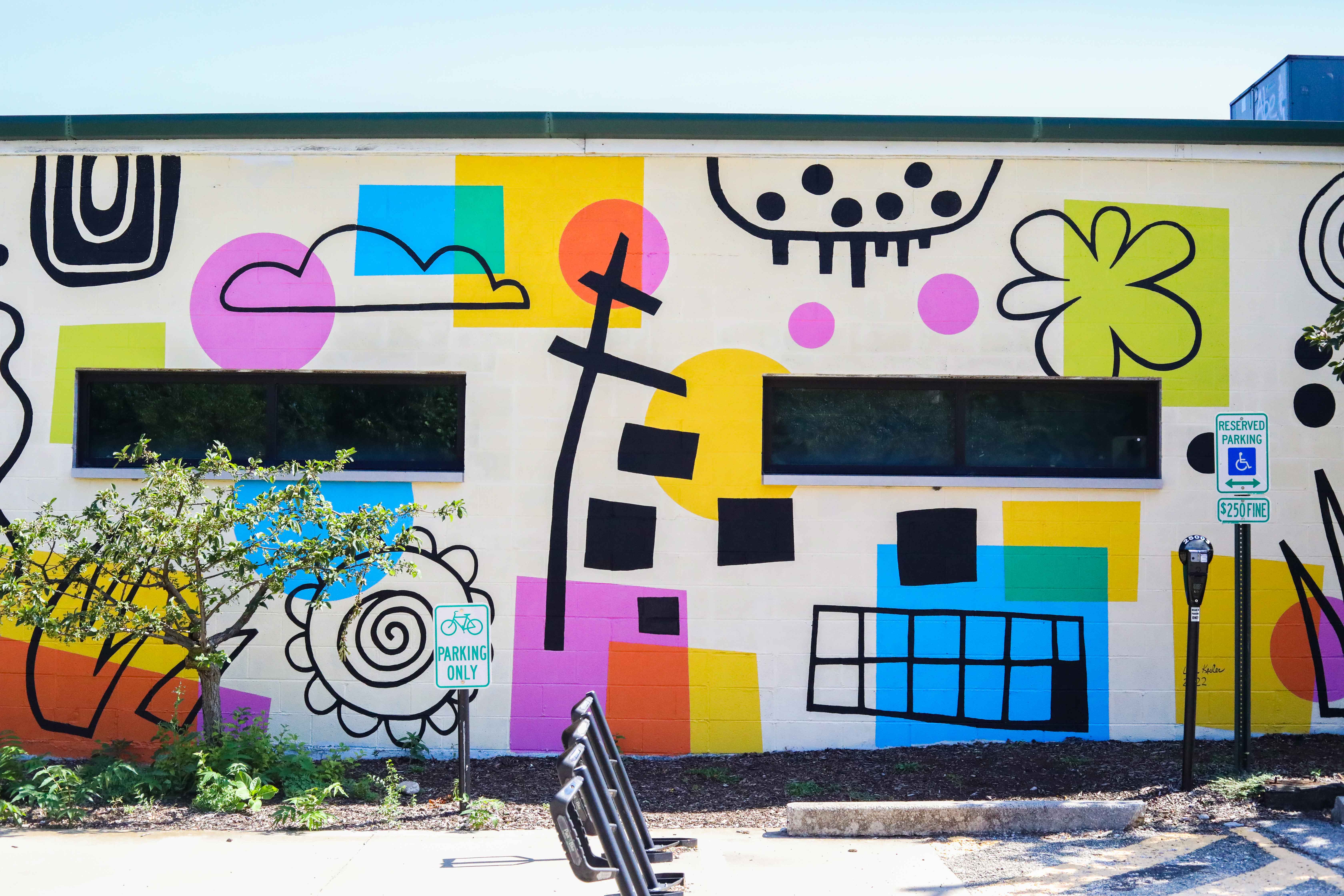 colorful mural on the side of a white painted building