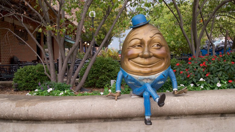 gold and blue statue of Humpty-Dumpty sitting on concrete