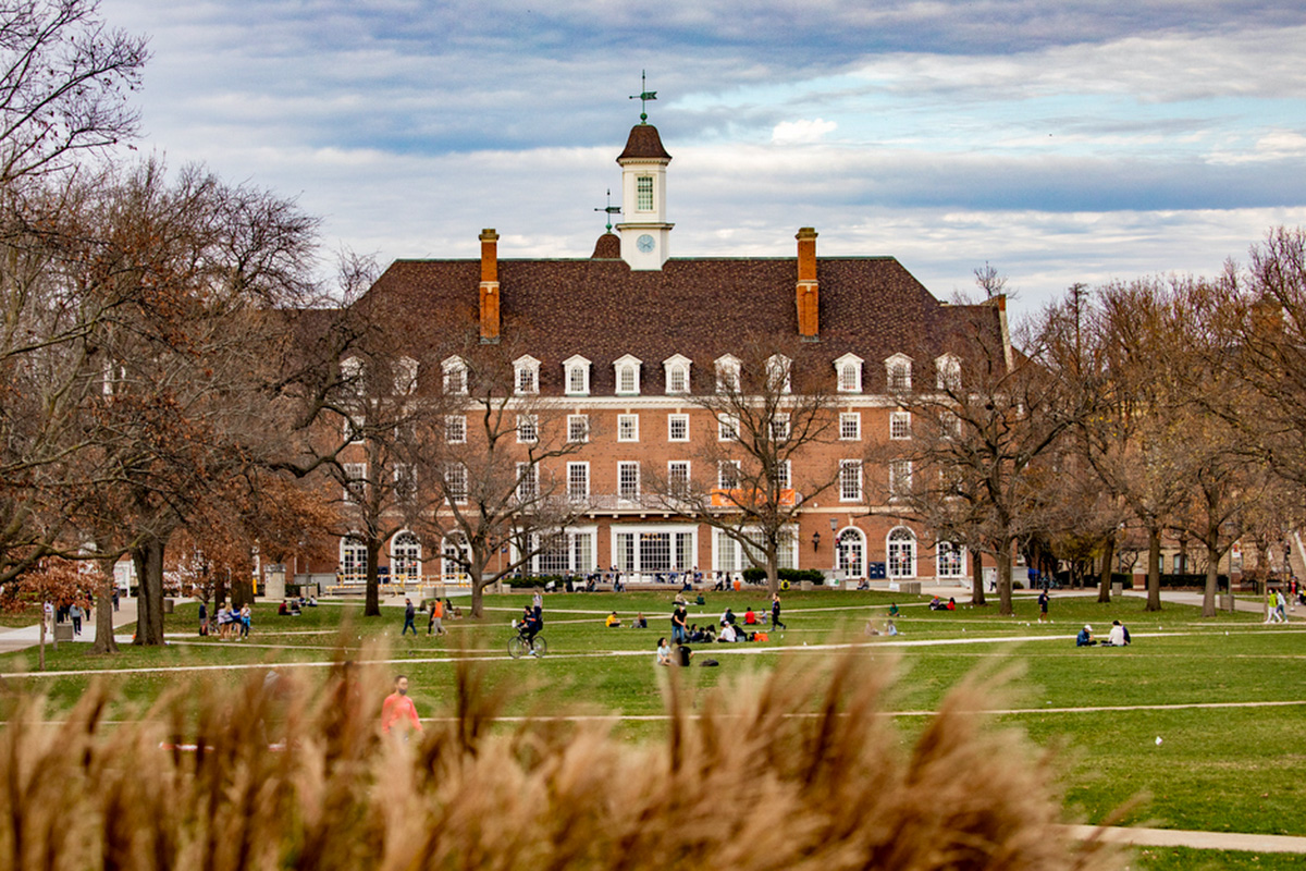 large brick building with white windows and trees in front