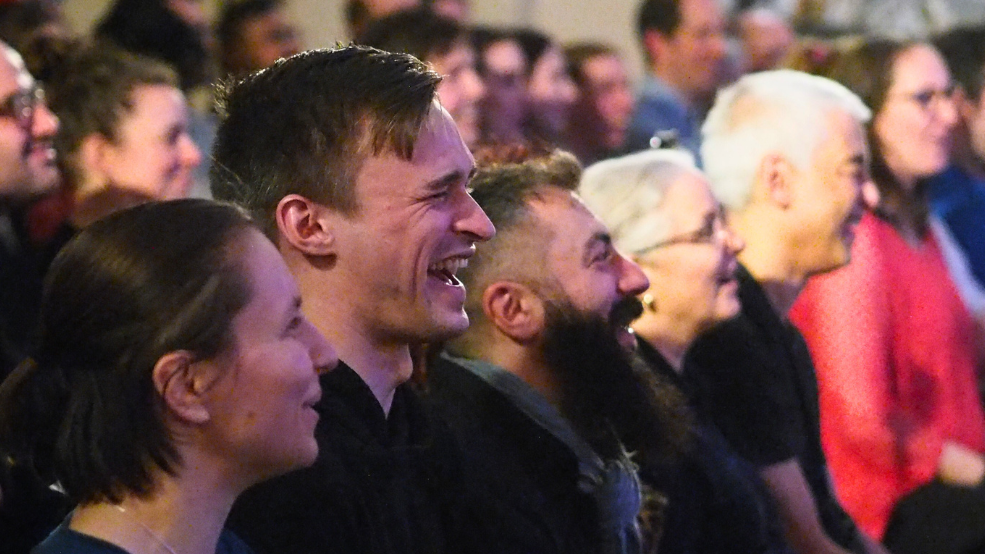 Audience of people laughing.